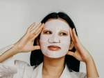 etalle de una modelo aplicando una mascarilla coreana de hidrogel transparente sobre la piel limpia e iluminada
