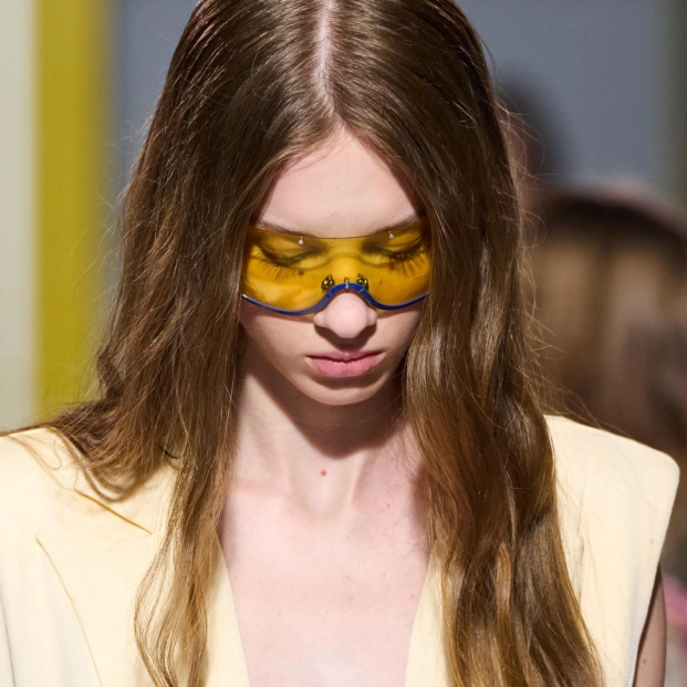 Mujer con melena castaña y gafas de cristales amarillos